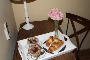 uma mesa com croissants e café e um vaso de flores em La Branda Brin Guest House em La Spezia