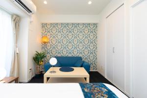 una camera da letto con un divano blu e un tavolo di Guest House One More Heart at TSUKIJI 1 a Tokyo
