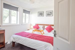 a bedroom with a bed with red pillows and a table at Stirling Venus Apartment - Scotland Holiday Let in Stirling