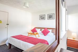 a bedroom with a large bed with pink pillows at Stirling Venus Apartment - Scotland Holiday Let in Stirling