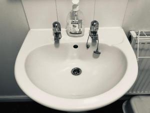 a white sink with a bottle of soap on it at WHOLE HOUSE with 3bedrooms New Build Nottingham 29 in Nottingham +100 photos