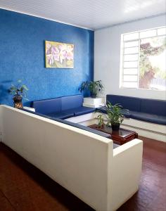 a living room with blue walls and a white couch at Hotel Monte Carlo in Pederneiras