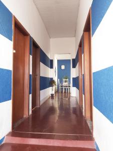 an empty hallway with blue and white walls and a table at Hotel Monte Carlo in Pederneiras