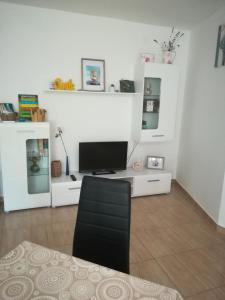 a living room with a television on a white cabinet at Apartman Nada in Kornić