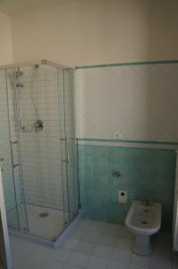 uma casa de banho com um chuveiro, um lavatório e um WC. em A casa dalla Fra 2 em Castelfranco Emilia