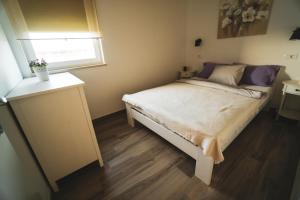 a small bedroom with a bed and a window at Enjoy Green, APP with swimming pool, garden, pets welcome in Novigrad Istria +21 photos