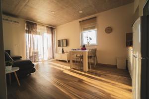 a living room with a table and a kitchen at Enjoy Green, APP with swimming pool, garden, pets welcome in Novigrad Istria