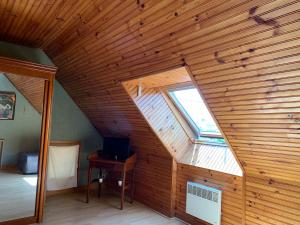 een zolderkamer met een houten plafond en een raam bij Gîte Chablisien in Chablis