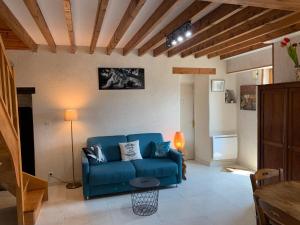 a living room with a blue couch and a table at Gîte Chablisien in Chablis