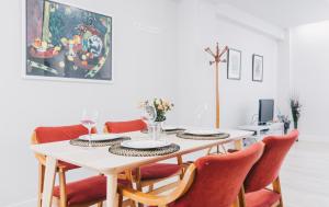 a dining room with a white table and red chairs at Epalza apartment by People Rentals in Bilbao
