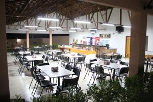 a cafeteria with tables and chairs in a building at Santa Rosa Hotel in Juazeiro do Norte