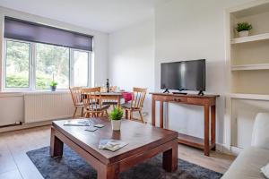 ein Wohnzimmer mit einem Tisch und einem TV in der Unterkunft Stirling Venus Apartment - Scotland Holiday Let in Stirling
