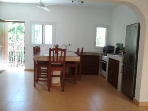 a kitchen with a table and chairs and a refrigerator at villa sur la plage et piscine in Mahajanga