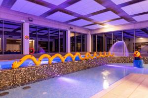 a swimming pool with an inflatable gym in a building at Apartamenty Aquamarina Onyx by Renters in Międzyzdroje