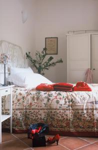 a bed with red pillows on it in a bedroom at Agriturismo Valcrosa in Diano Castello