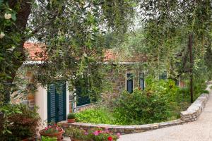 a building with green shutters and flowers in a garden at Agriturismo Valcrosa in Diano Castello