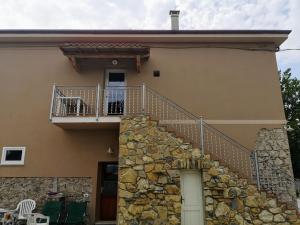 a house with a staircase and a stone wall at La California in Marina di Bibbona