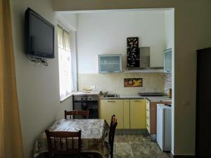 a kitchen with a table and a tv on the wall at La California in Marina di Bibbona +11 photos