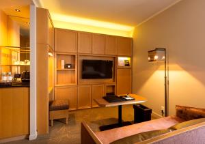 ein Hotelzimmer mit einem Schreibtisch und einem TV in einem Zimmer in der Unterkunft Royal Park Hotel Takamatsu in Takamatsu