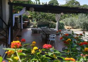 a patio with a table and a bunch of flowers at La terra dei ciliegi tra l'Etna e il mare di Taormina in Piedimonte Etneo