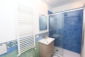 ein blau gefliestes Bad mit einem Waschbecken und einer Dusche in der Unterkunft Casa Nautilus in Amalfi