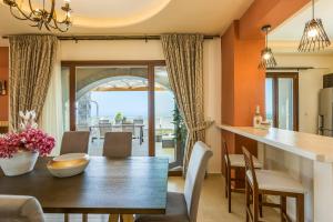 a kitchen and dining room with a wooden table and chairs at New Villa Kantifes 4 Families or Couples with Private Pool & BBQ in Kiriánna
