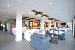eine Lobby mit weißen Sofas, Tischen und Stühlen in der Unterkunft Vila Bisera in Ohrid