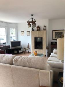 a living room with a couch and a fireplace at Casa Bella Vista en montaña con vistas al mar y piscina privada in Cunit