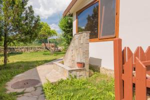 a house with a stone staircase next to a fence at Стаи за гости АЯКС Guest rooms AJAX in Kranevo