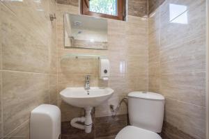 a bathroom with a toilet and a sink at Стаи за гости АЯКС Guest rooms AJAX in Kranevo