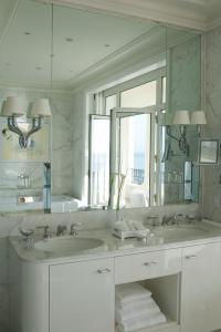 a bathroom with two sinks and a large mirror at Grand-Hôtel du Cap-Ferrat, A Four Seasons Hotel in Saint-Jean-Cap-Ferrat