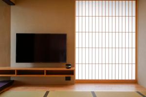 a flat screen tv sitting on a entertainment center in a room at Kaminarimon Ryokan in Tokyo