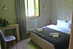 sypialnia z łóżkiem z dwoma ręcznikami w obiekcie Shino w mieście Stepancminda