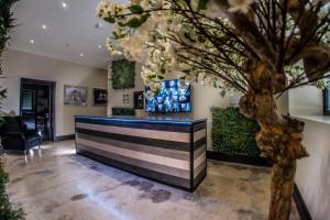 a lobby with a counter with a tree in the foreground at Hotel 21 in Southport