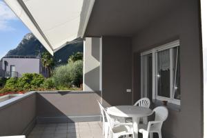 patio con mesa y sillas en el balcón en Villa Dina, en Riva del Garda