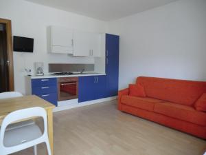 sala de estar con sofá rojo y armarios azules en Villa Dina, en Riva del Garda