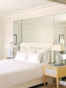 a bedroom with a large white bed with two lamps at Grand-Hôtel du Cap-Ferrat, A Four Seasons Hotel in Saint-Jean-Cap-Ferrat