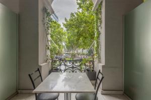 a table and chairs on a balcony with a window at Badagoni Boutique Hotel Rustaveli in Tbilisi City