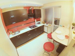 a small kitchen with a table and red chairs at Apartment on Lenin Avenue in Gomel