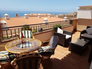 a patio with a table and chairs on a balcony at Residencial Playa de La Arena in Puerto de Santiago