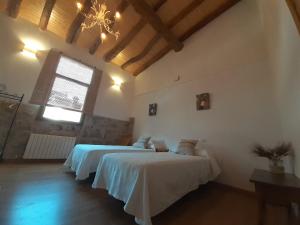 a bedroom with two beds and a window at Casa La Foradada in Corbera