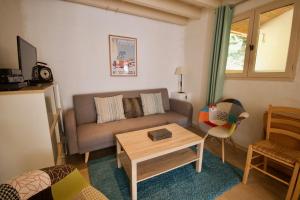 a living room with a couch and a table at Le Cuvier in Sarlat-la-Canéda