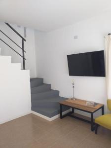 a living room with a tv and a table and stairs at Las Toscas Apart in Curuzú Cuatiá