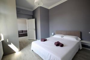 a bedroom with a white bed with purple towels on it at Romantic Panorama Krakivska street in Lviv