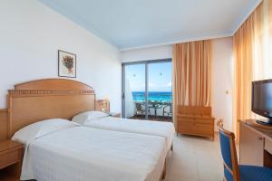 a hotel room with two beds and a view of the ocean at Blue Horizon in Ialysos