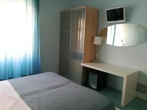 1 dormitorio con cama, escritorio y espejo en Rock Garden, en Gaeta