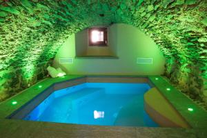 - une piscine dans une grotte avec un tunnel dans l'établissement Au coeur du village Chambes d'hôtes & SPA, à Arnad