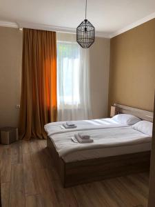 Schlafzimmer mit einem großen Bett und einem Fenster in der Unterkunft Apartments Baqari Inn in Kazbegi