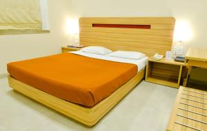 a bedroom with a large bed with a wooden headboard at Rama Krishna Hotel in Mumbai