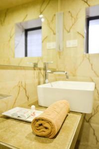 een badkamer met een wastafel en een handdoek op een aanrecht bij Rama Krishna Hotel in Mumbai